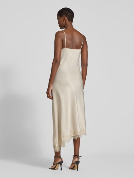 Frauenmodel trägt Maxikleid mit Spitzenbesatz von VERO MODA in glänzendem Unifarben-Look, Spitzenmuster, Satin, Ganzkörperansicht Rückansicht