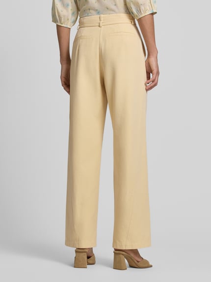 Frauenmodel trägt Stoffhose mit Gürtel und Eingrifftaschen von JAKE*S STUDIO WOMAN in Beige, ausgestellter Schnitt, Reine Baumwolle, Ganzkörperansicht Rückansicht.