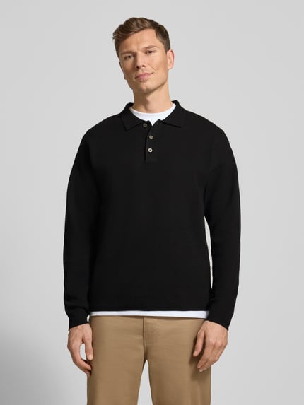 Męski model nosi Strickpullover mit Polokragen Modell 'BLABRADFORT' od Jack & Jones Premium, czarny, luźny krój, widok całej sylwetki z przodu.