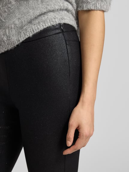 Frauenmodel trägt Skinny Fit Hose aus Viskose-Mix von s.Oliver BLACK LABEL mit schimmernder Optik, Stretch-Webstruktur, Nahaufnahme Oberkörper.