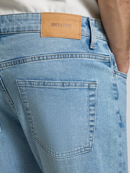 Männermodel trägt Regular Fit Jeans aus Baumwoll-Mix Modell 'WEFT' von Only & Sons in Hellblau mit Label Patch, Nahaufnahme Rückansicht.