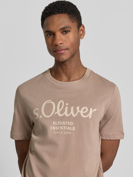 Männermodel trägt Regular Fit T-Shirt aus reiner Baumwolle von s.Oliver RED LABEL in Unifarben mit Label-Print, Nahaufnahme Oberkörper.