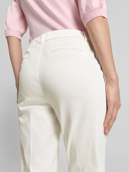 Kobiece model prezentuje spodnie z bawełny z domieszką elastanu, krój slim fit, Hose mit Eingrifftaschen Modell 'DAYS CIGARET PANTS' od B.Young, kolor jasny, szerokość w rozmiarze 36: 40 cm, długość wewnętrzna nogawki w rozmiarze 36: 76 cm, widok całej sylwetki z tyłu