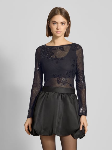 Frauenmodel trägt Slim Fit Longsleeve mit floralem Pailettenbesatz von Gina Tricot, schwarz, semitransparent, Ganzkörperansicht von vorne.