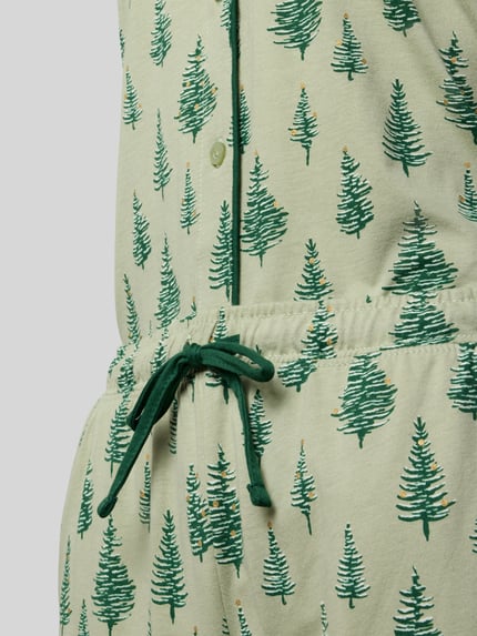 Frauenmodel trägt Pyjama aus reiner Baumwolle Modell 'X-Mas' von LASCANA mit grünem Tannenbaum-Muster, Tunnelzug, Nahaufnahme Oberkörper.
