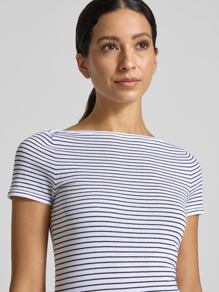 Frauenmodel trägt Skinny Fit T-Shirt aus reiner Baumwolle von MANGO, weiß mit schwarzen Streifen, kurzärmelig, U-Boot-Ausschnitt, Nahaufnahme Oberkörper.