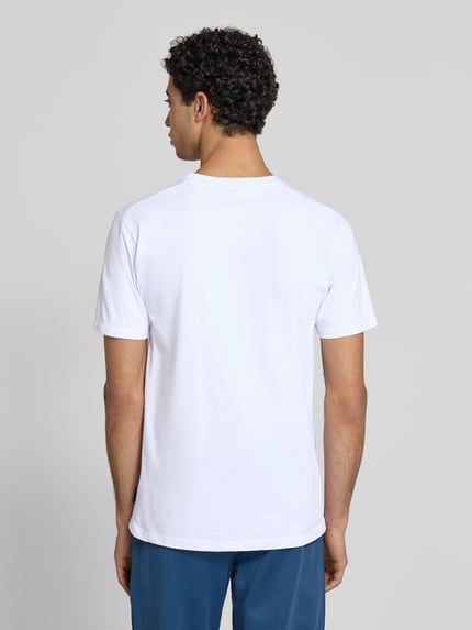 Männermodel trägt T-Shirt mit Label-Stitching Modell 'CASSICA' von Ellesse aus reiner Baumwolle, gerader Schnitt, Ganzkörperansicht Rückansicht.