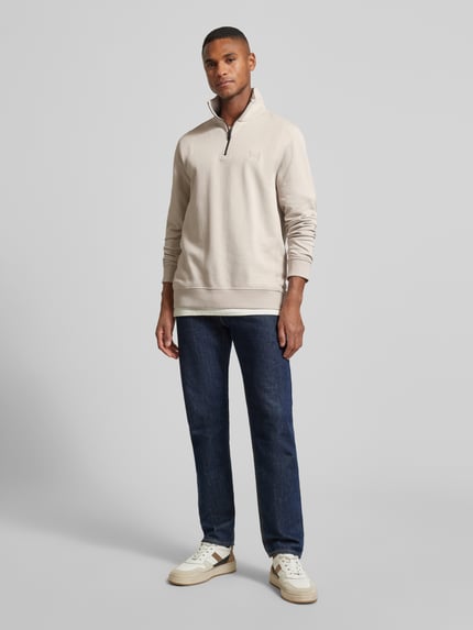 Männermodel trägt Regular Fit Sweatshirt aus reiner Baumwolle Modell 'ZETRUST' von BOSS Orange, Optik: Unifarben, Troyer-Kragen, Label-Patch, Materialverarbeitung: Baumwoll-Terry, Ganzkörperansicht von vorne.