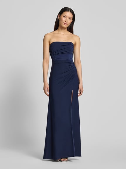 Frauenmodel trägt Slim Fit Abendkleid in Maxilänge mit Gehschlitz von Hey Kyla, Elastischer-Material-Mix, Schulterfrei, Dunkelblau, Raffung, Ganzkörperansicht von vorne. Rückenlänge bei Größe 36: 132 cm, Brustweite bei Größe 36: 28 cm.