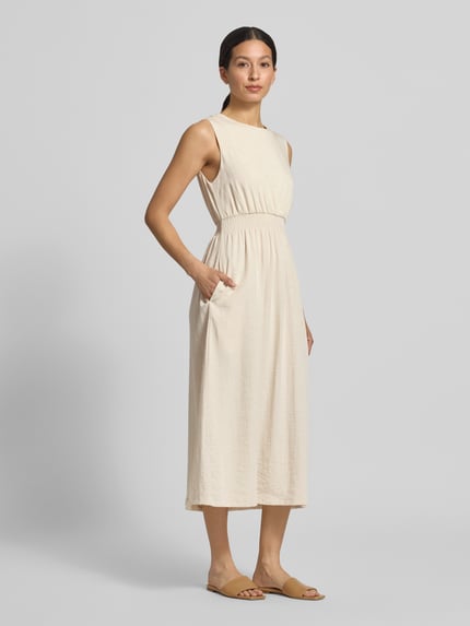 Frauenmodel trägt Midikleid aus Viskose-Mix mit Leinen-Anteil von MSCH Copenhagen, Taillierte Passform, Rundhalsausschnitt, Ärmelloses-Design, Cremefarbe, weiche Textur Modell 'Daria', Rückenlänge 110 cm, Brustweite 32 cm, Ganzkörperansicht von vorne.