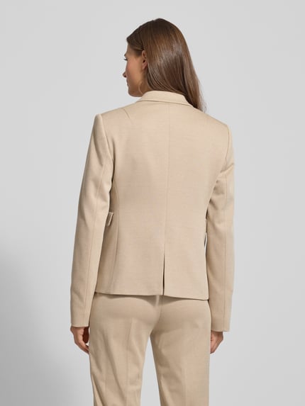 Männermodel trägt taillierter Blazer aus Viskose-Mix Modell 'JIA13' von BOSS, beżowy, wzór kratka, długi rękaw, tkanina gładka, Ganzkörperansicht Rückansicht.