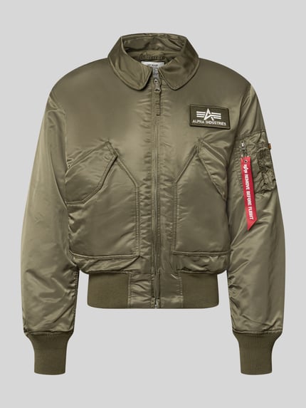 Produktfoto, Bomberjacke mit seitlichen Pattentaschen und Label-Patch von Alpha Industries in Olivgrün, Reißverschluss, glatte Oberfläche, gerippte Abschlüsse