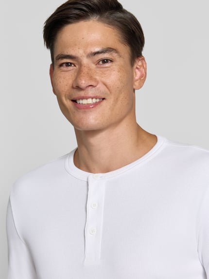 Męski model nosi t-shirt in Ripp-Optik mit Rundhalsausschnitt von Jake*s, mieszanka bawełny i elastanu, krój slim fit, długość tyłu 56 cm, zbliżenie na górną część ciała.