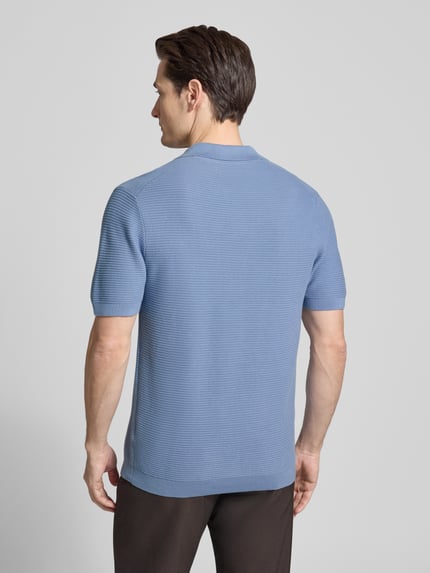 Männermodel trägt gebreid shirt met polokraag en V-hals van Christian Berg Men, puur katoen, regular fit, ruglengte maat M 73 cm, mouwlengte maat M 27 cm, blauwe kleur, gestructureerde textuur, ganzkörperansicht rückansicht.
