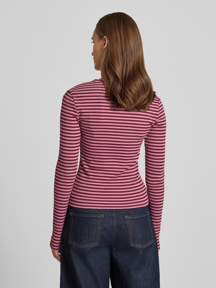 Frauenmodel trägt Slim Fit Langarmshirt mit Rundhalsausschnitt von REVIEW, elastischer Baumwoll-Mix, rosa-rote Streifen, Ganzkörperansicht Rückansicht.