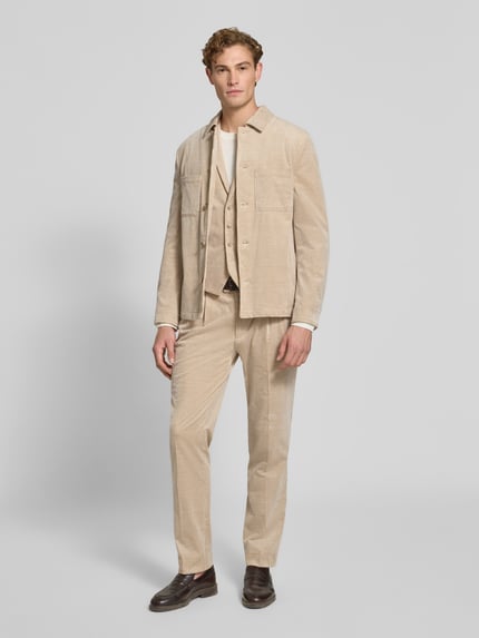 Männermodel trägt Slim Fit Hemdjacke aus Cord von MCNEAL, Baumwoll-Elasthan-Mix, Kentkragen, Brusttaschen, Ganzkörperansicht von vorne.