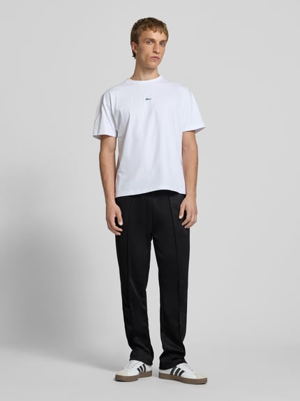 Mannenmodel draagt Trackpants met lengtenaden model 'Motus' van Pegador, relaxte fit, katoenmix, elastische taille, zwarte stof, volledige lichaamsaanzicht van voren.