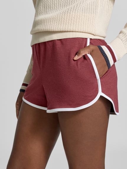 Frauenmodel trägt Regular Fit Shorts mit elastischem Bund Modell 'Marty' von VARLEY in Rot mit weißer Paspel, Nahaufnahme Oberschenkel, elastischer Material-Mix, verlagerte Rückseite, Damen Shorts