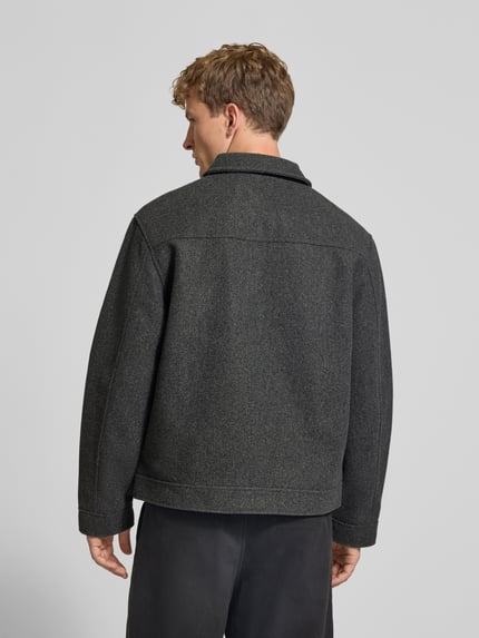 Männermodel trägt Jacke mit Label-Stitching von REVIEW in Dunkelgrau, strukturierte Oberfläche, Rückenansicht, Ganzkörperansicht Rückansicht. Kontext: Regular Fit, Umlegekragen, Reißverschluss, Eingrifftaschen, Rückenlänge 67 cm, Schulterbreite 50 cm, Brustweite 59 cm, Ärmellänge 64 cm.