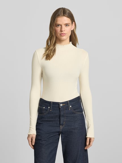Frauenmodel trägt Slim Fit Langarmshirt aus Lyocell-Mix von Marc O'Polo Denim, Optik: Unifarben, hochgeschlossen, Frill-Abschlüsse, Ganzkörperansicht von vorne.