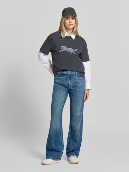 Frauenmodel trägt Regular Fit Bootcut-Jeans mit Paperbag-Bund von Rabanne aus blauem Denim im Used Look, 5-Pocket-Design, Medium Wash, Ganzkörperansicht von vorne.
