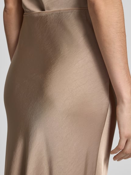 Frauenmodel trägt Maxirock aus Satin Modell 'Vicky' von Neo Noir, glänzende beige A-Linie, elastischer Bund, Nahaufnahme Oberkörper.
