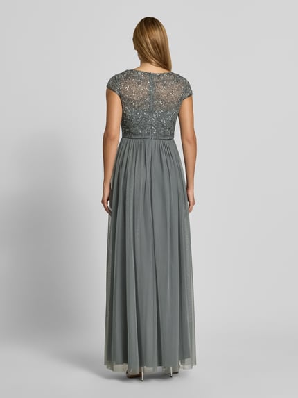 Frauenmodel trägt Abendkleid mit Pailletten von Christian Berg Cocktail in Grau, taillierte Passform, Ziersteinbesatz, Ganzkörperansicht Rückansicht.