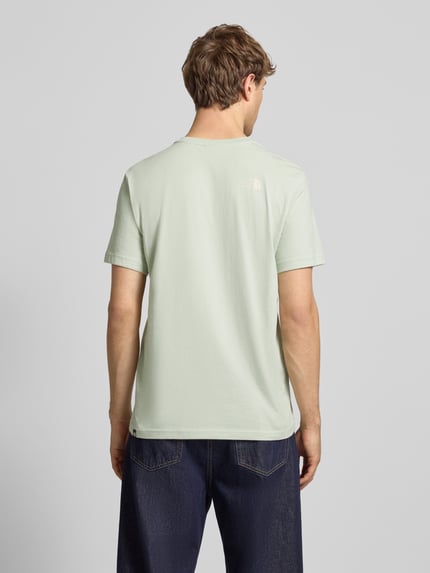 Männermodel trägt T-Shirt mit Label-Print von The North Face aus Baumwoll-Mix, Regular-Fit, in Hellgrün, Rückenlänge 71 cm, Ganzkörperansicht Rückansicht.
