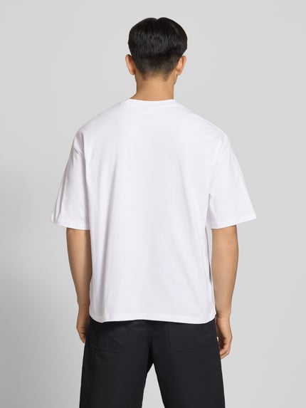 Männermodel trägt T-Shirt mit Logo- und Motiv-Print von REVIEW, Herren T-Shirt aus Reine Baumwolle, Loose-Fit, Ganzkörperansicht Rückansicht.