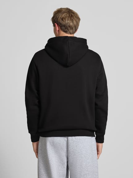 Männermodel trägt Regular Fit Hoodie aus reiner Baumwolle mit Label-Detail von Alpha Industries, Schwarz, Rückenansicht, Ganzkörperansicht Rückansicht