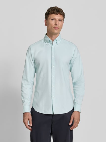 Männermodel trägt Regular Fit Freizeithemd aus reiner Baumwolle Modell 'RICKERT' von BOSS Orange in Hellblau, Ganzkörperansicht von vorne.