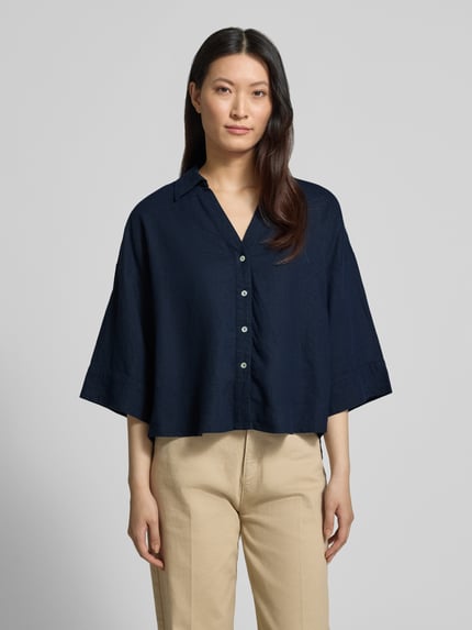 Modelka kobieca ma na sobie Boxy Fit Bluse mit V-Ausschnitt Modell 'Lava' od FREE/QUENT, ciemnogranatowy len i wiskoza, kołnierzyk koszulowy, dekolt w serek, zapięcie na guziki, rękaw 3/4, widok całej sylwetki z przodu.