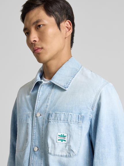 Męski model nosi Relaxed Fit Hemdjacke in Denim-Optik od Closed z bawełny, nakładane kieszenie, listwa guzikowa, jasnoniebieska, zbliżenie górna część ciała