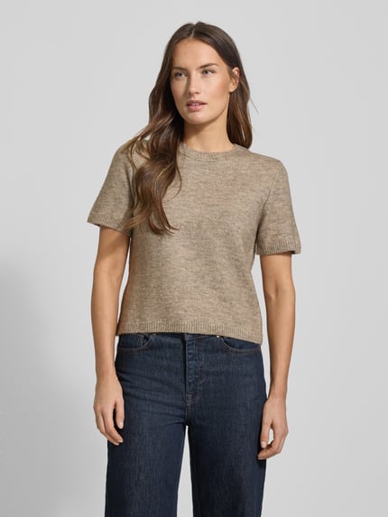 Frauenmodel trägt Kurzarm Strickpullover mit gerippten Abschlüssen Modell 'NEKKA' von Mango in Beige, Regular-Fit, Material-Mix mit Woll-Anteil, Damen, Rundhalsausschnitt, Rückenlänge 48 cm, Ärmellänge 22 cm, Unifarben, strukturierte Textur, Ganzkörperansicht von vorne.
