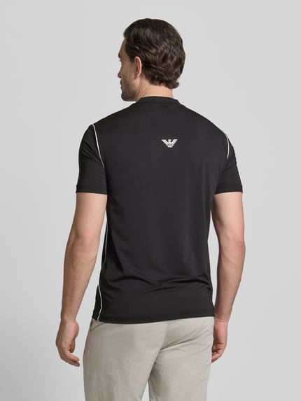 Männermodel trägt Regular Fit T-Shirt mit Stehkragen von EA7 Emporio Armani in Schwarz mit Label-Print, Ganzkörperansicht Rückansicht.