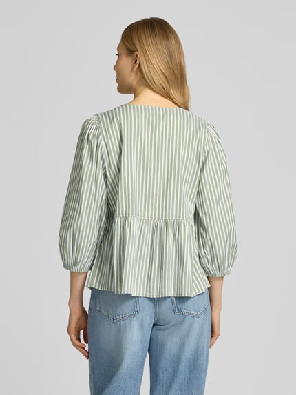 Frauenmodel trägt Relaxed Fit Bluse aus Viskose-Mix von s.Oliver RED LABEL in Optik:Allover-Muster, gestreift, Schleifendetails und Raffung, grün-weiß, 3/4-Arm, Ärmelabschluss elastisch, Materialverarbeitung: Popeline, Ganzkörperansicht Rückansicht