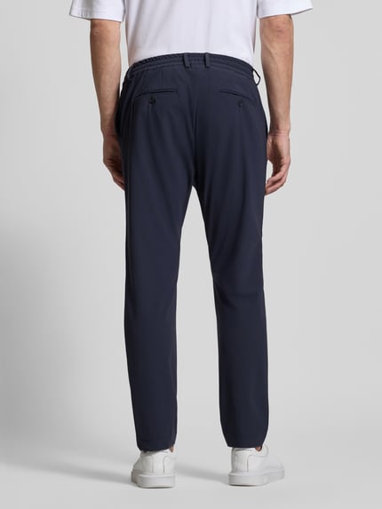 Mannelijk model draagt Slim Fit Hose mit Paspeltaschen am Gesäß van CRUNA in donkerblauw materiaalmix met stretch, steekzakken, paspelzakken achter. Ganzkörperansicht Rückansicht.