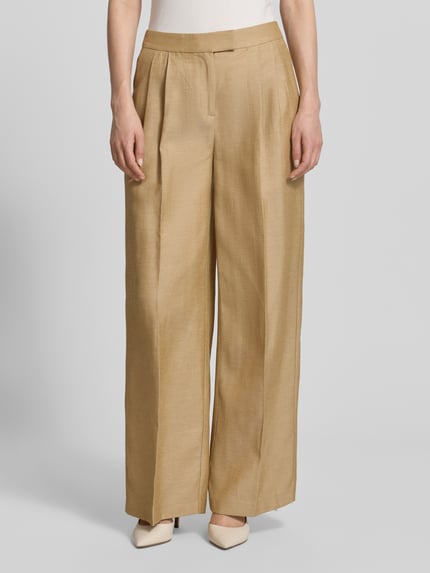 Frauenmodel trägt Wide Fit Stoffhose mit Lyocell-Anteil von Comma, Material-Mix, Bügelfalten, Bundfalten, Eingrifftaschen, Haken- und Reißverschluss, Bundweite 38 cm, Innenbeinlänge 77 cm, sandfarbener Stoff mit glatter Textur, Ganzkörperansicht von vorne.