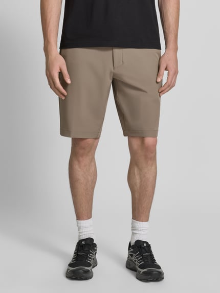 Mannenmodel draagt Slim Fit Chinoshorts met persplooien van BOSS Green in beige, gladde textuur, Ganzkörperansicht van voren.