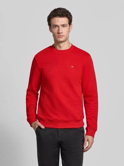 Männermodel trägt sweatshirt met labelstitching Model 'BALIS' van Napapijri in puur katoen, regular fit, ronde hals, ruglengte maat M 68 cm, mouwlengte maat M 69 cm, helderrood met fijne textuur, helemaal vooraan gezien