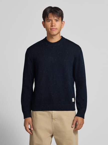 Männermodel trägt Regular Fit Strickpullover mit Rundhalsausschnitt von JACK & JONES in donkerblauw met fijne spikkel, ribboorden, Materiaalmix met katoen, logopatch, lange mouwen, ruglengte maat M 66 cm, mouwlengte 64 cm, ganzkörperansicht van voren.