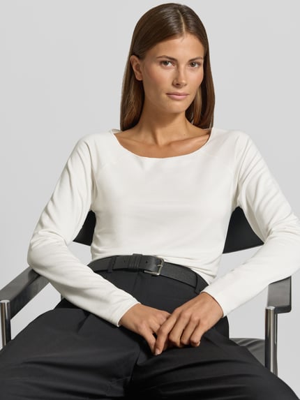 Vrouwenmodel draagt Regular Fit Longsleeve aus Viskose-Mix van monari, effen wit, ronde hals, shirt met lange mouwen, ruglengte maat 36: 56 cm, mix van viscose en modal, elastisch materiaal, nahaufnahme bovenlichaam.