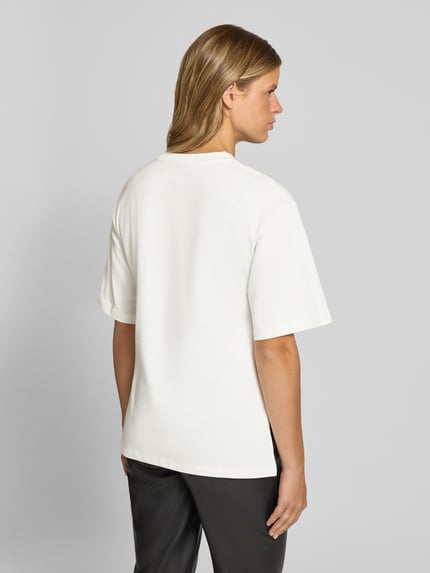 Frauenmodel trägt Longshirt mit Rundhalsausschnitt und Tunnelzug von Gina Tricot, Baumwolle, weiß, lockerer Schnitt, Rückansicht, KI-modifiziertes Bild