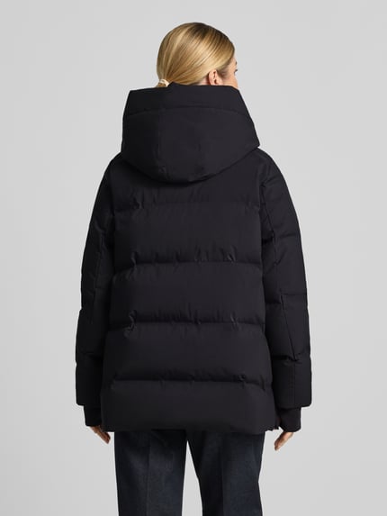 Frauenmodel trägt Regular Fit Daunenjacke mit abnehmbaren Rucksackgurten von Marc O'Polo, schwarze Farbe, Ganzkörperansicht Rückansicht. Damen Daunenjacke von Marc O'Polo.