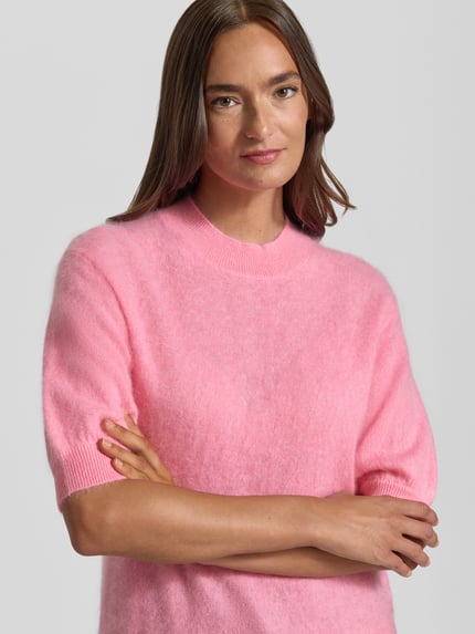 Frauenmodel trägt Regular Fit Pullover aus Kaschmir-Mix mit Woll-Anteil von HERZENS, rosa, Strick-Optik, Nahaufnahme Oberkörper.