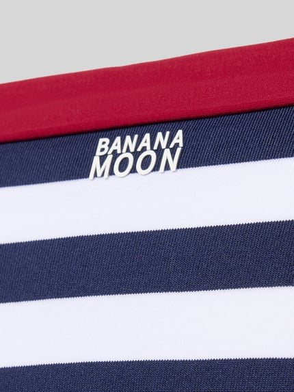 Produktfoto, Bikinihose mit seitlicher Schnürung Modell 'SADIA NAVY' von Banana Moon im Allover-Look, navy-weiß gestreift, Material-Mix mit Stretch-Anteil, körpernahe Passform, rote Kante, strukturierte Oberfläche