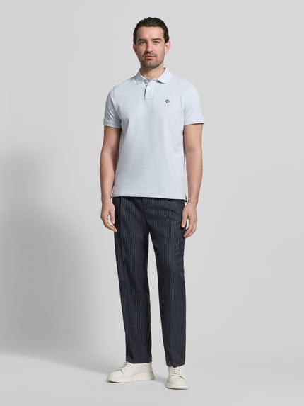 Męskmodel nosi Slim Fit Poloshirt mit Logo-Stitching von MCNEAL, czysta bawełna, krój slim fit, jasny kolor, widok całej sylwetki z przodu.