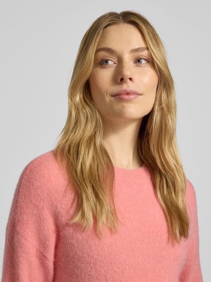 Vrouwenmodel draagt Gebreide pullover met ronde hals Model 'Festina Hope' van MSCH Copenhagen in zachte roze tint, materiaalmix met alpaca, regular fit, detailopname bovenlichaam.