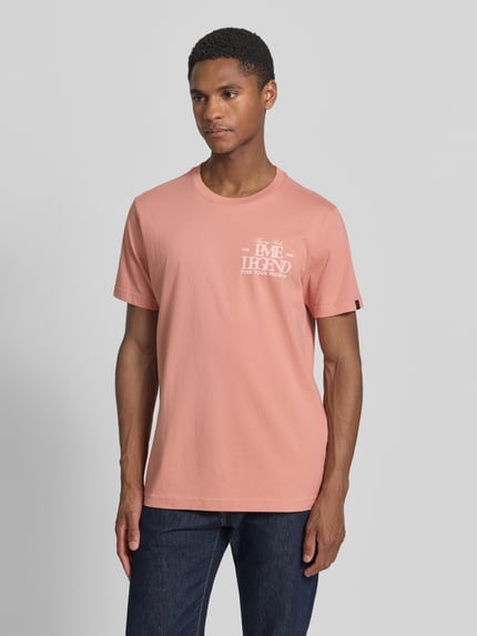 Mannenmodel draagt T-shirt met Label-Print en Rundhalsausschnitt van PME Legend in zalmroze, puur katoen, regular fit, ruglengte maat M 70 cm, labelprint, ronde hals. Ganzkörperansicht van voren.