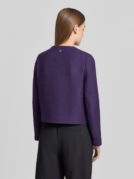 Frauenmodel trägt Kurzblazer mit goldfarbenen Zierknöpfen von JOOP!, lila unifarben, strukturierte Webware, Ganzkörperansicht Rückansicht.